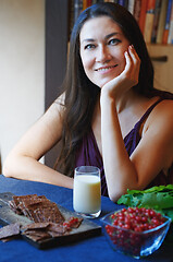 Image showing Vegan woman sitting at the table with healthy food