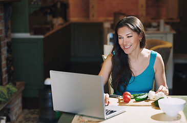 Image showing Woman at the table with vegetables working via laptop