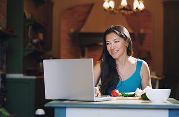 Image showing Woman at the table with vegetables working via laptop