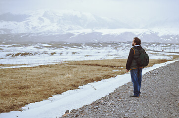 Image showing Touris wearing backpack and standing at the rural road while loo