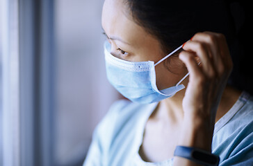 Image showing Woman staying at home wearing protective surgical mask