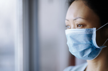 Image showing Woman staying at home wearing protective surgical mask