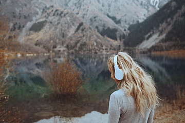 Image showing Woman wearing wireless headshot at the mountain lake