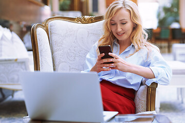 Image showing Businesswoman using smartphone in the modern bank lobby