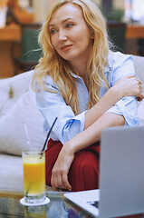 Image showing Woman relaxing at the hotel lobby and blogging via laptop