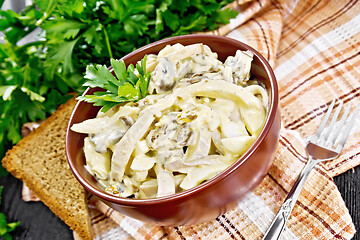 Image showing Salad with squid and champignons in bowl on napkin