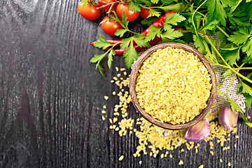 Image showing Bulgur in bowl with vegetables on wooden board top