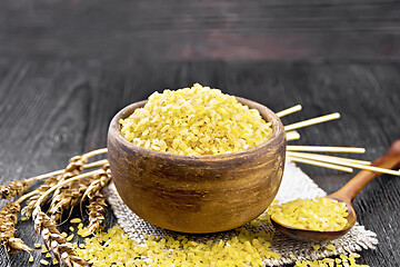 Image showing Bulgur in bowl on dark wooden board