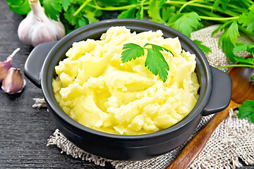 Image showing Potatoes mashed in saucepan on dark board