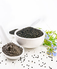 Image showing Seeds of black cumin in bowl on light wooden board