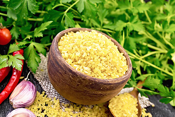 Image showing Bulgur in bowl with vegetables on dark wooden board