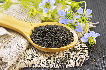 Image showing Seeds of black cumin in spoon on dark board