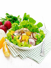 Image showing Salad of radish and orange with mint on light wooden board