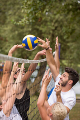 Image showing group of young friends playing Beach volleyball