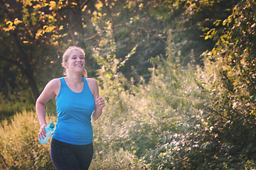 Image showing woman jogging along a country road