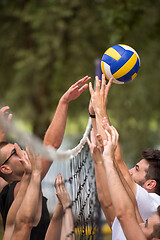 Image showing group of young friends playing Beach volleyball