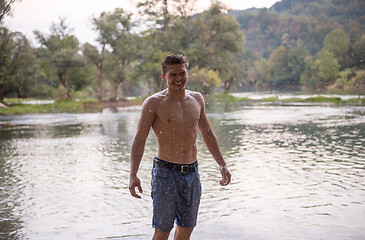 Image showing man with a bare torso splashing water