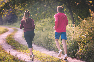 Image showing young couple jogging along a country road