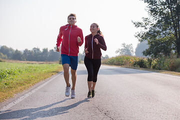 Image showing young couple jogging along a country road