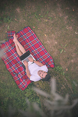 Image showing top view of man using a laptop computer under the tree