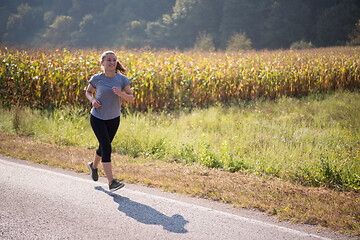 Image showing woman jogging along a country road