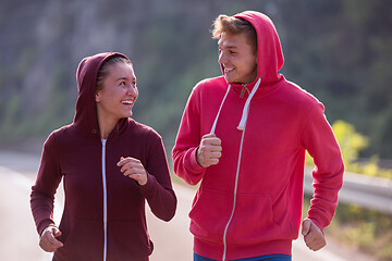 Image showing young couple jogging along a country road