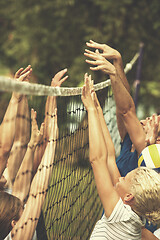 Image showing group of young friends playing Beach volleyball