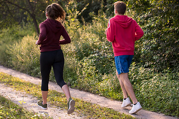 Image showing young couple jogging along a country road