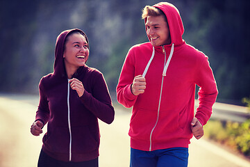 Image showing young couple jogging along a country road