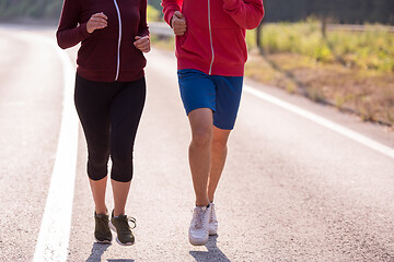 Image showing young couple jogging along a country road