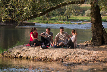 Image showing friends smoking hookah on the river bank