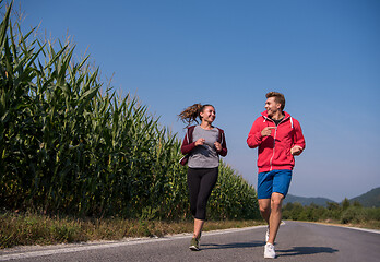 Image showing young couple jogging along a country road