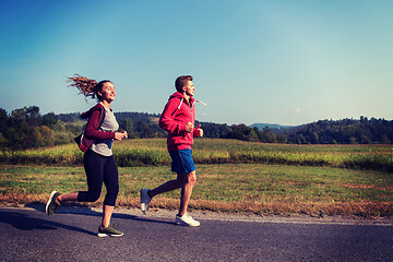 Image showing young couple jogging along a country road