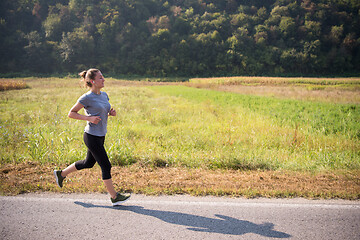 Image showing woman jogging along a country road