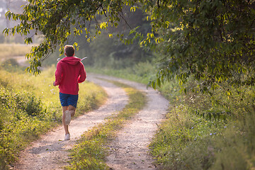 Image showing man jogging along a country road