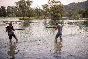 Image showing young men having fun with water guns