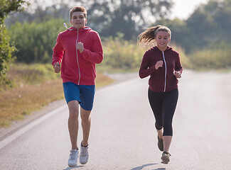 Image showing young couple jogging along a country road