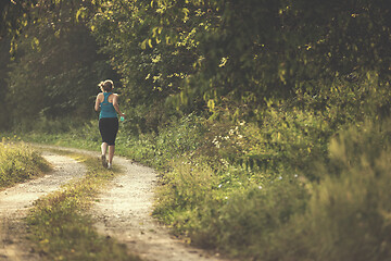 Image showing woman jogging along a country road