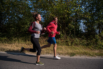 Image showing young couple jogging along a country road