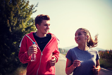 Image showing young couple jogging along a country road