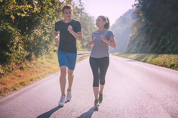 Image showing young couple jogging along a country road