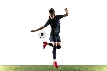 Image showing Female soccer player kicking ball isolated over white background