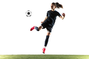 Image showing Female soccer player kicking ball isolated over white background