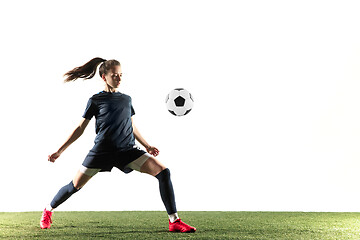 Image showing Female soccer player kicking ball isolated over white background