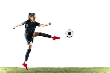 Image showing Female soccer player kicking ball isolated over white background