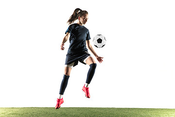 Image showing Female soccer player kicking ball isolated over white background