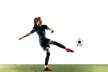 Image showing Female soccer player kicking ball isolated over white background