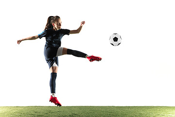 Image showing Female soccer player kicking ball isolated over white background