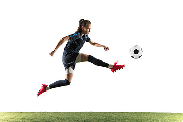 Image showing Female soccer player kicking ball isolated over white background