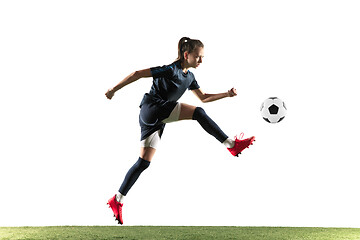 Image showing Female soccer player kicking ball isolated over white background